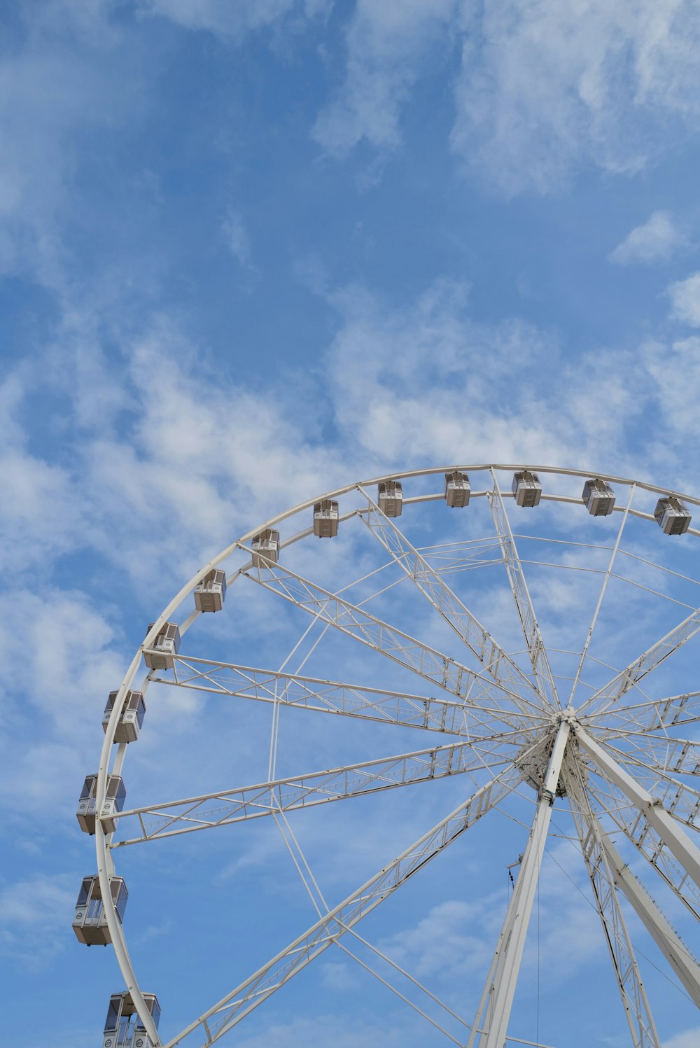 a ferris wheel against a blue sky with clouds