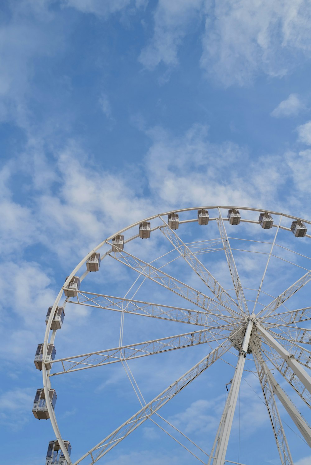 Ein Riesenrad vor blauem Himmel mit Wolken