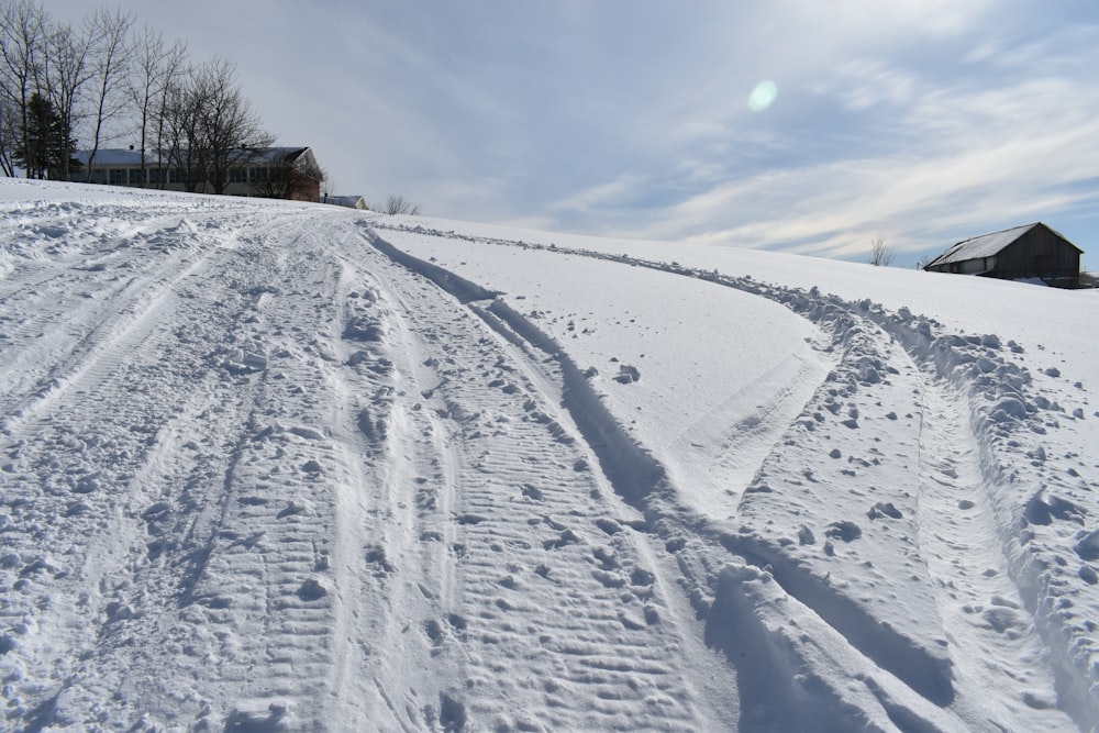 a snow covered hill with a house in the distance