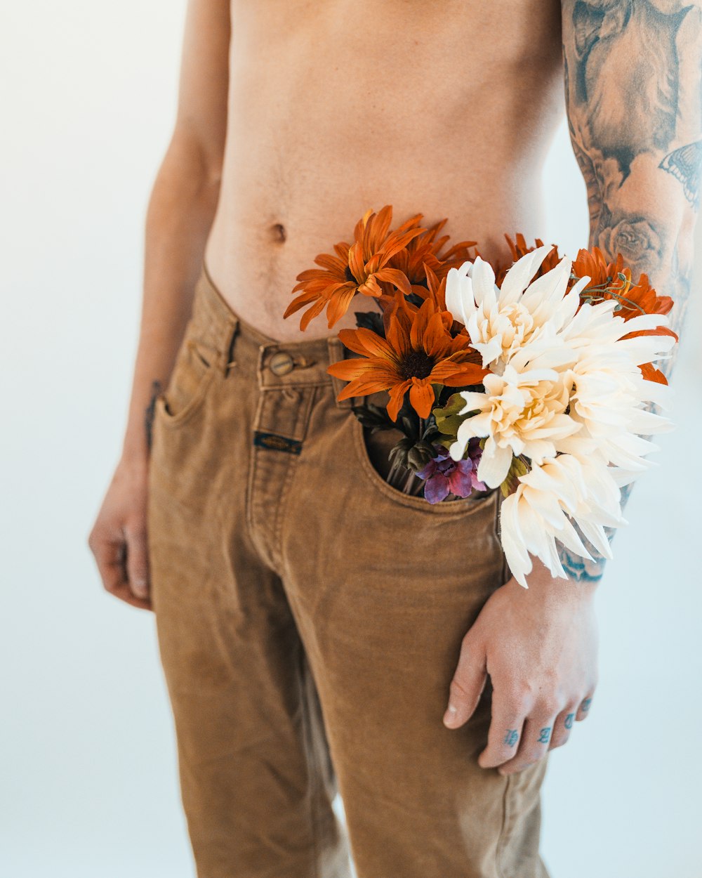 a man with a tattoo holding a bouquet of flowers in his pocket