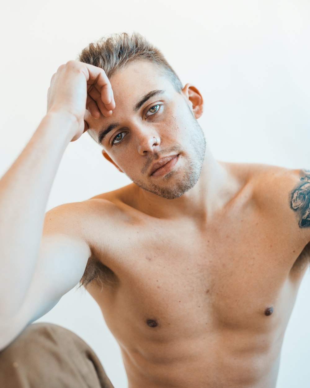 a shirtless man with a tattoo on his arm