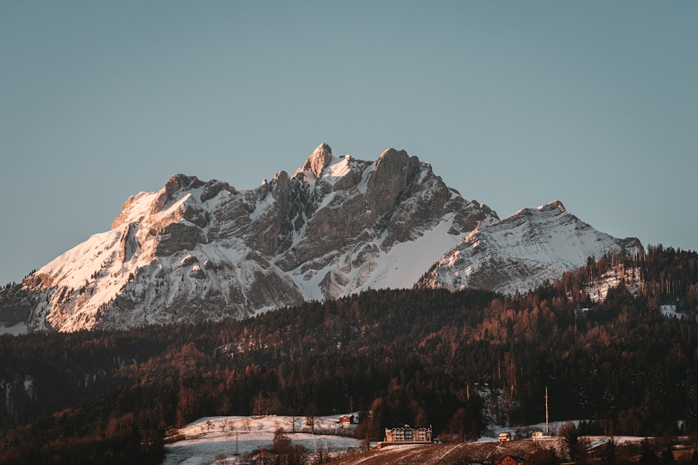 a snow covered mountain with a village below it