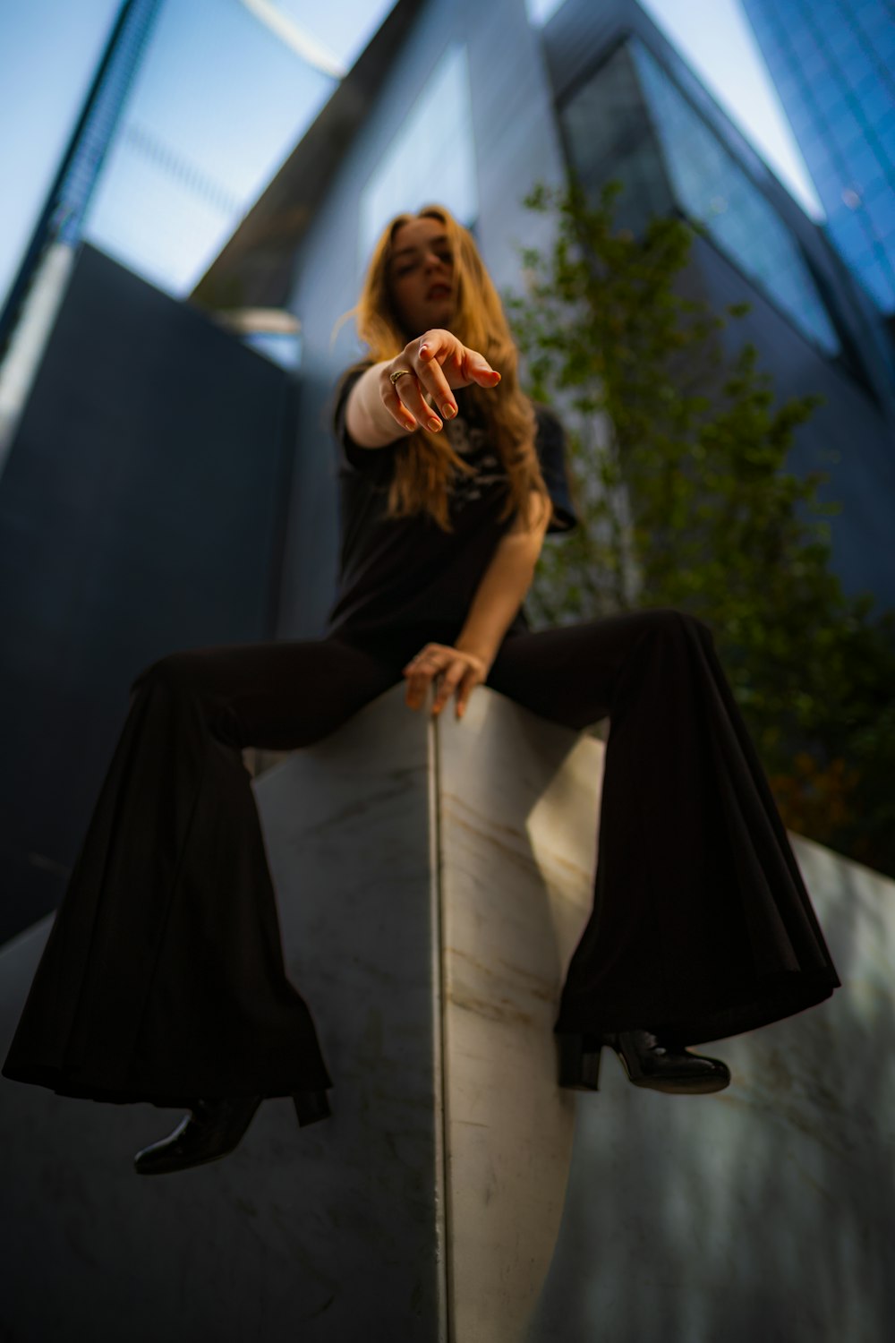 a woman sitting on top of a metal pole