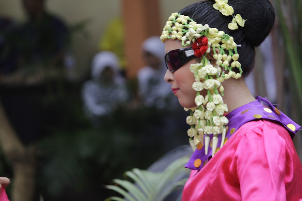 a woman in a pink dress with flowers in her hair