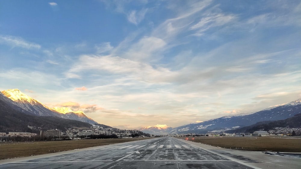 an empty runway with mountains in the background