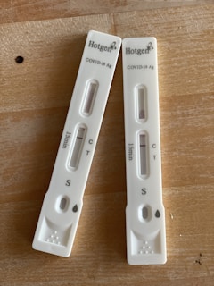 two nintendo wii controllers sitting on top of a wooden table