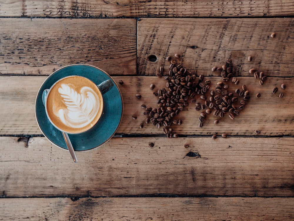 a cup of coffee with a leaf on top of it