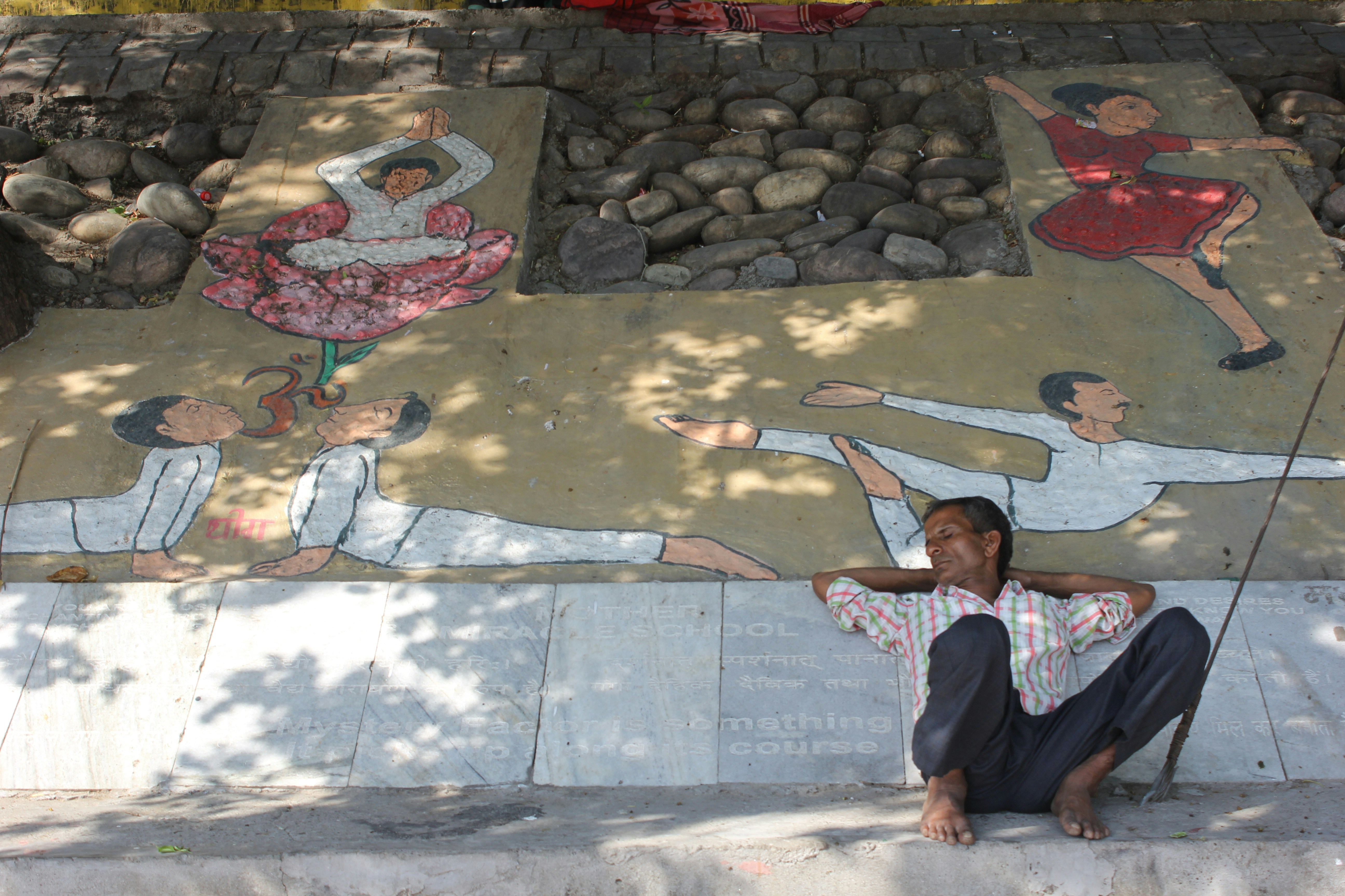 Eine Frau sitzt auf dem Boden vor einem Wandbild