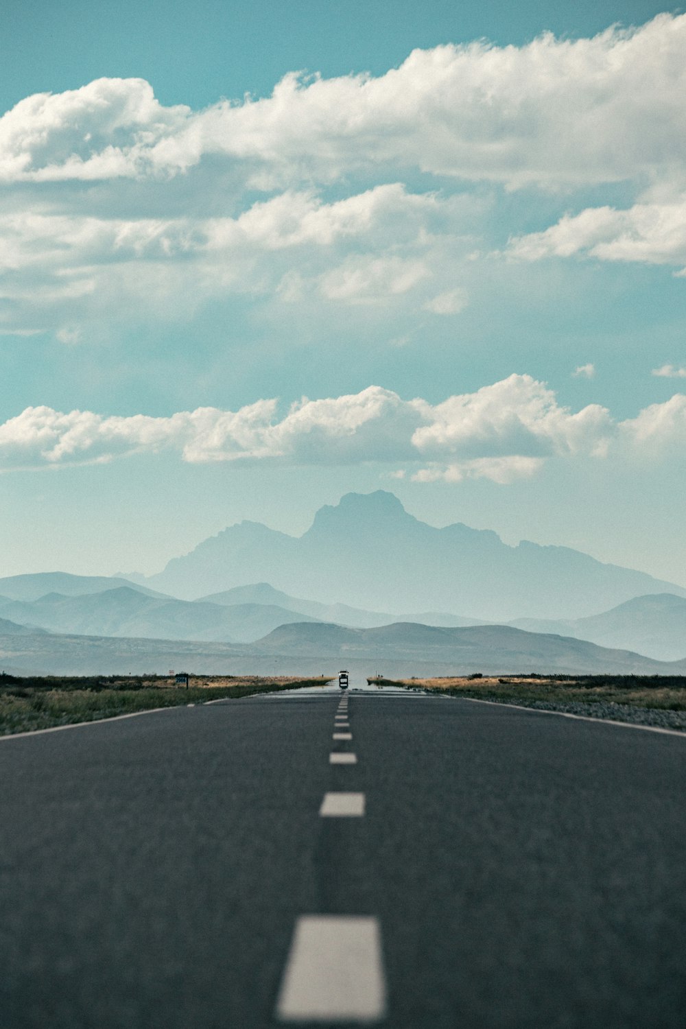 an empty road with mountains in the background