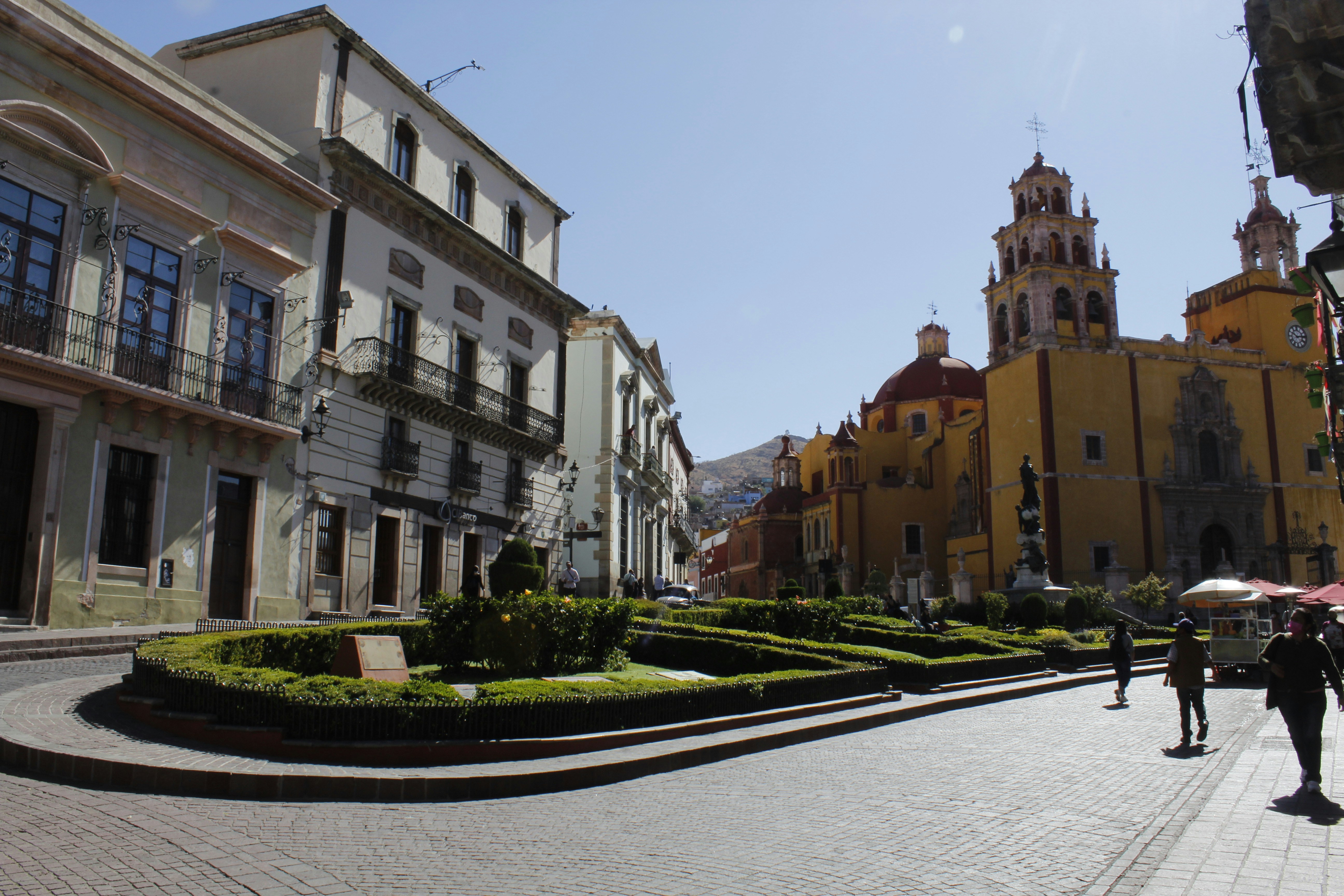 a group of people walking down a street next to tall buildings