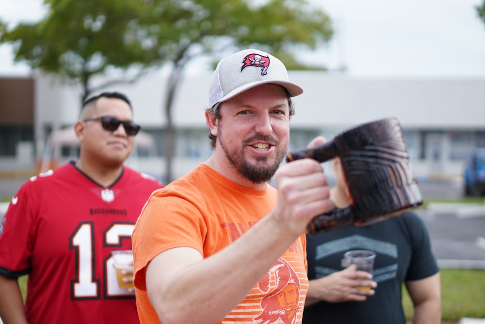 a man in an orange shirt holding a baseball glove