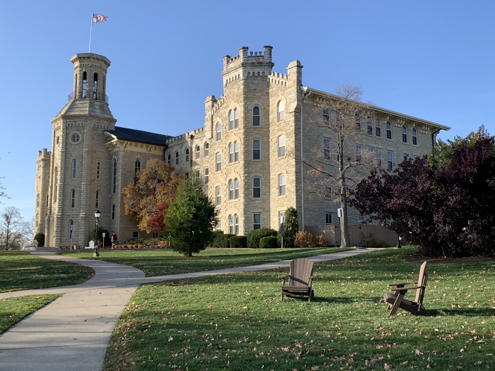 two chairs sitting on the grass in front of a large building