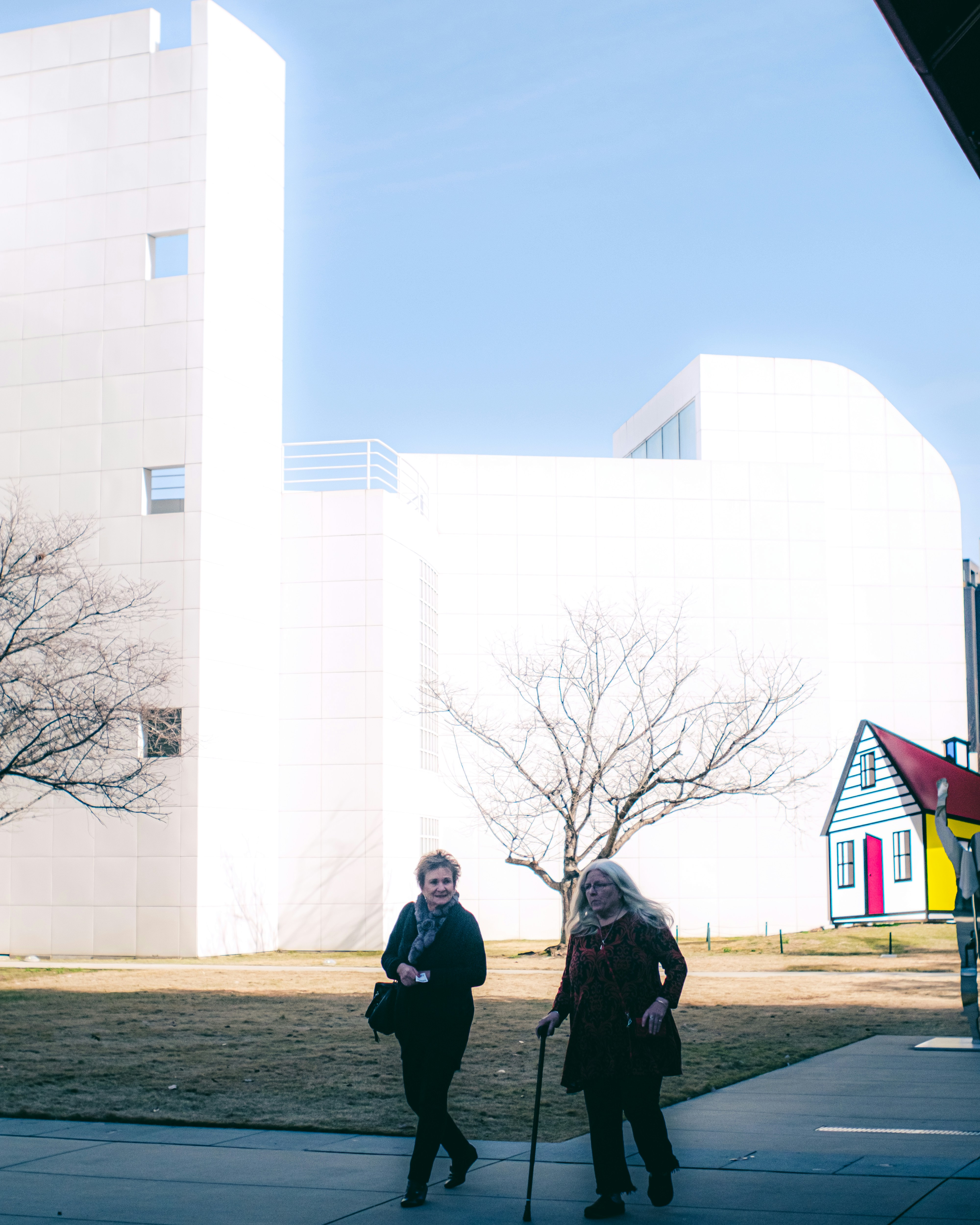 a couple of women standing next to each other on a sidewalk