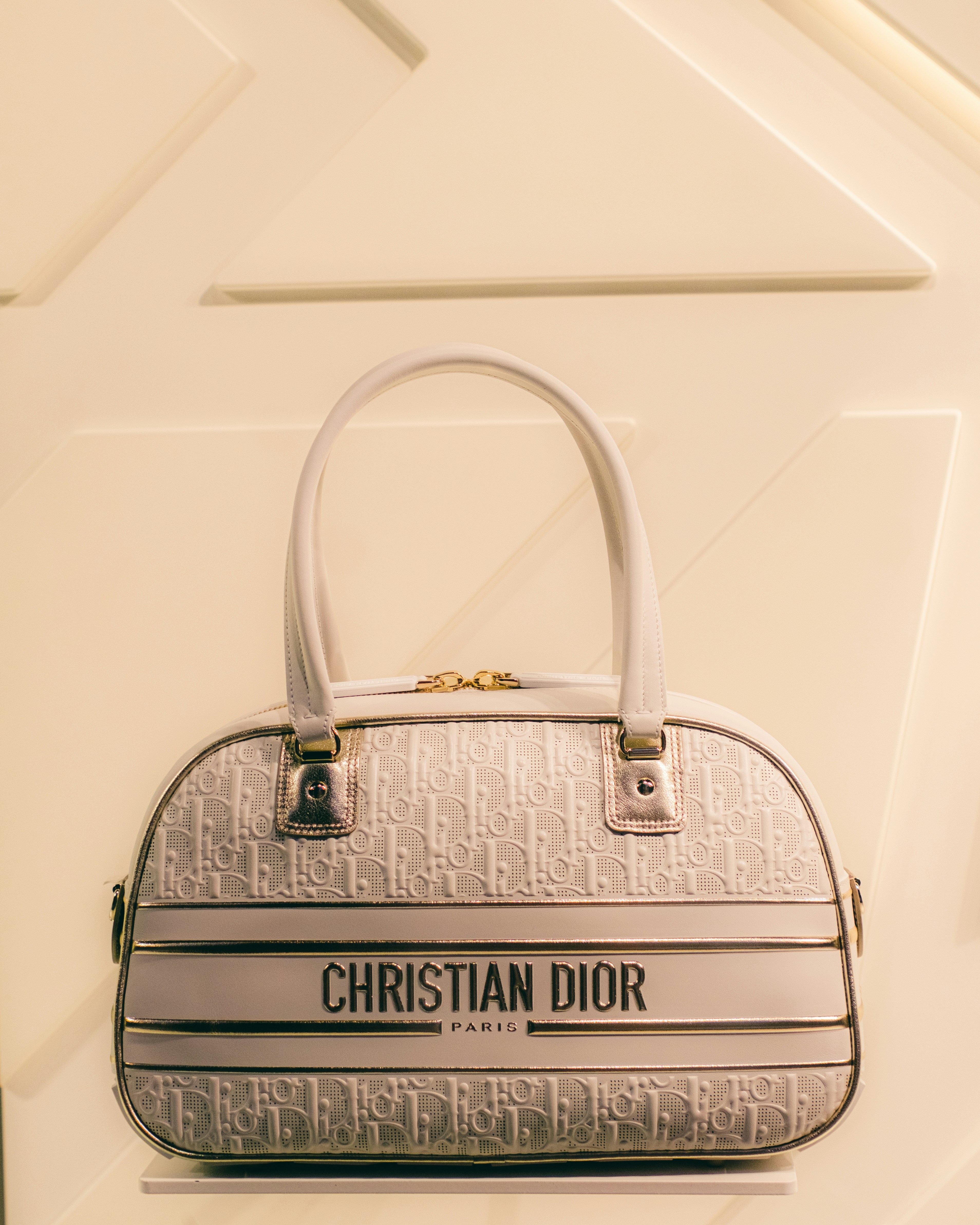 a christian dior bag hanging on a wall