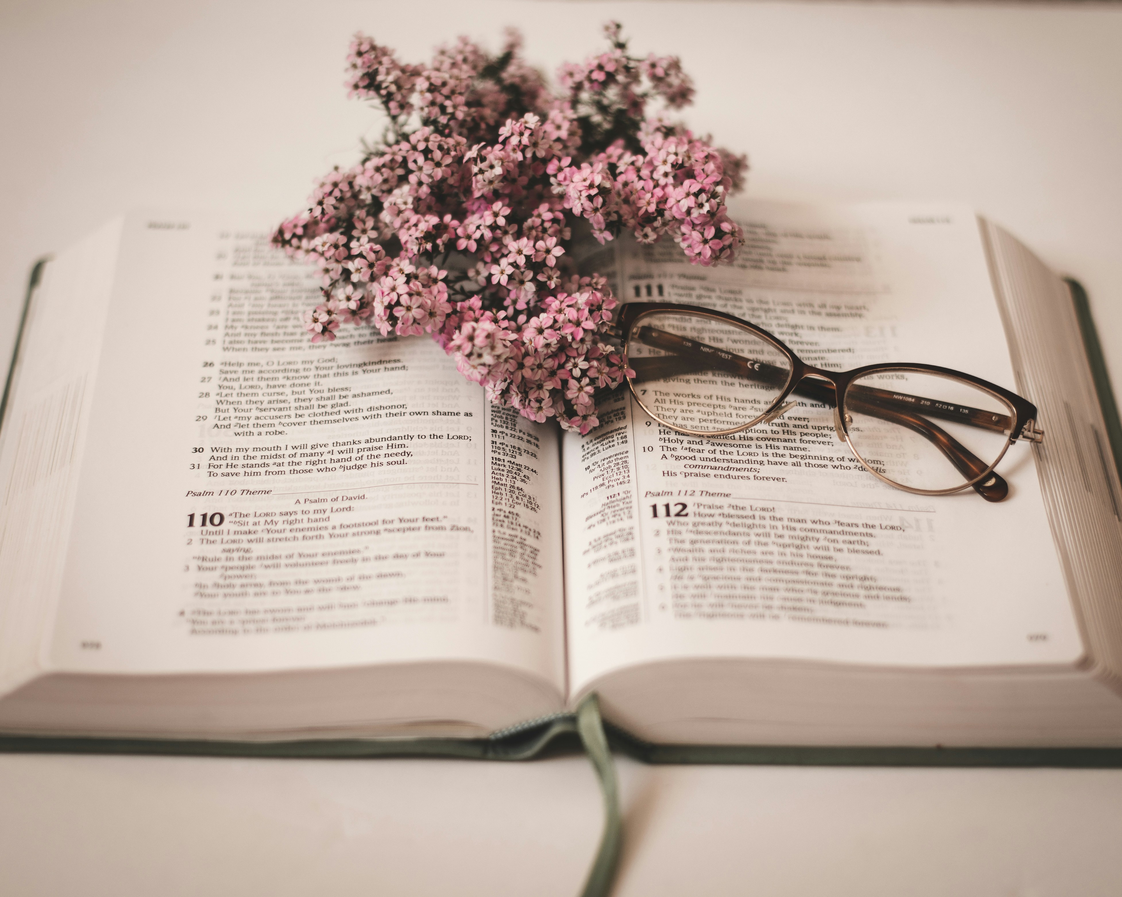 an open book with glasses on top of it