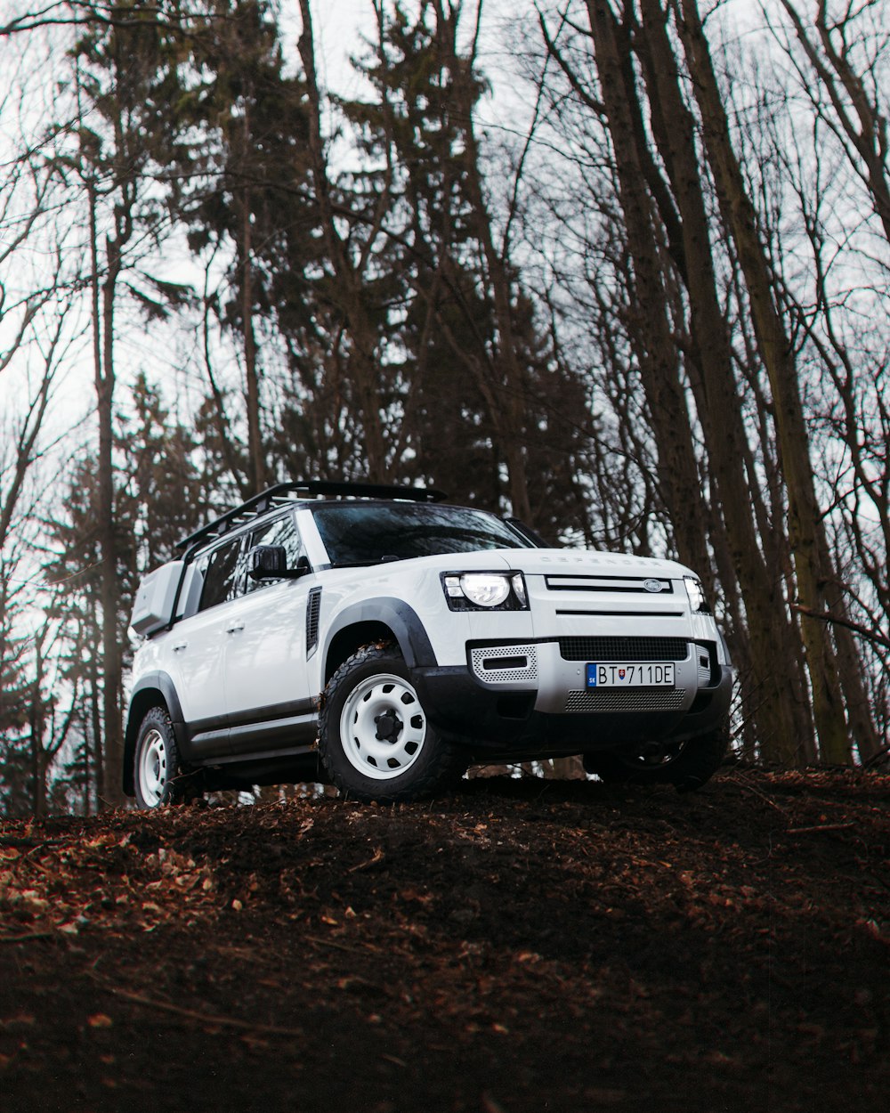 a white car parked on top of a dirt hill