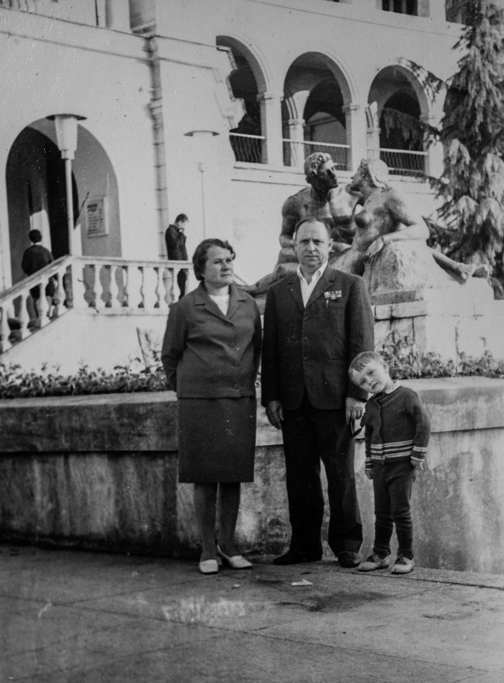 a black and white photo of two people and a child