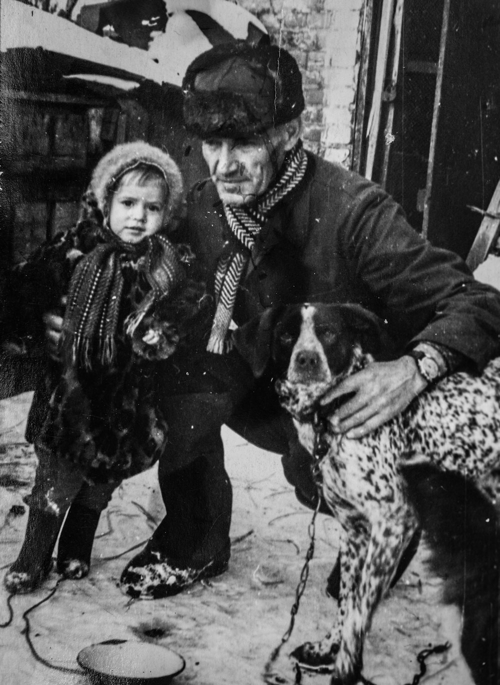 an old photo of a man and a child with a dog