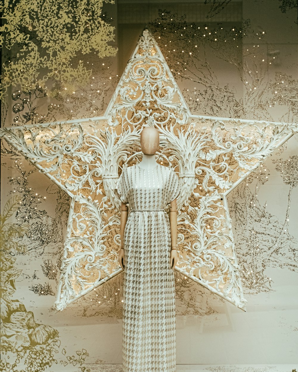a mannequin dressed in a white dress standing in front of a star
