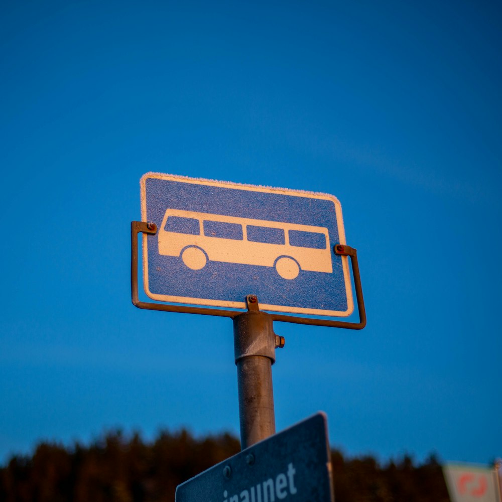 uma placa de rua azul com um ônibus sobre ele