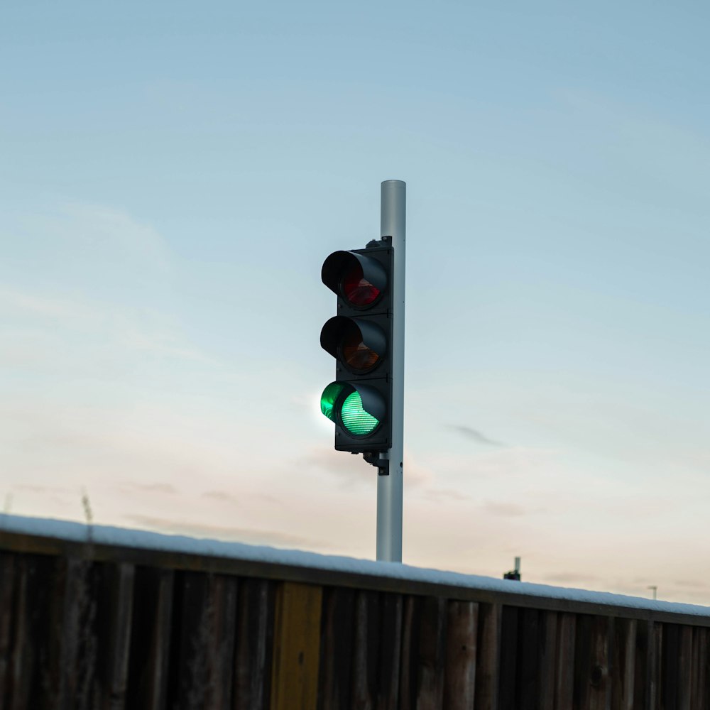 a traffic light on a pole with a sky background