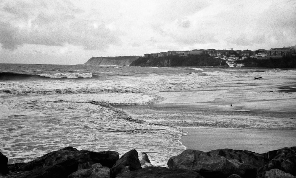 a black and white photo of a beach with waves