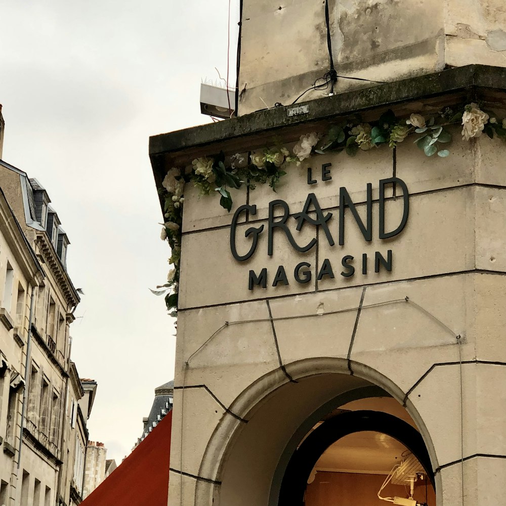 Ein Schild an der Seite eines Gebäudes, auf dem Grand Magasin steht