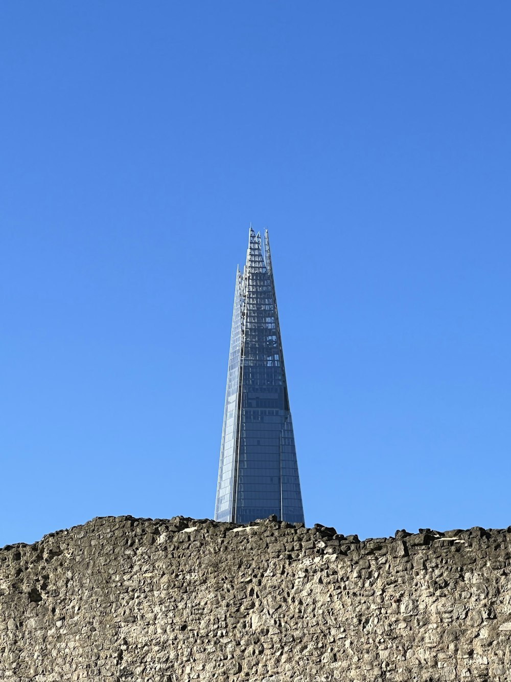 a very tall building sitting on top of a stone wall