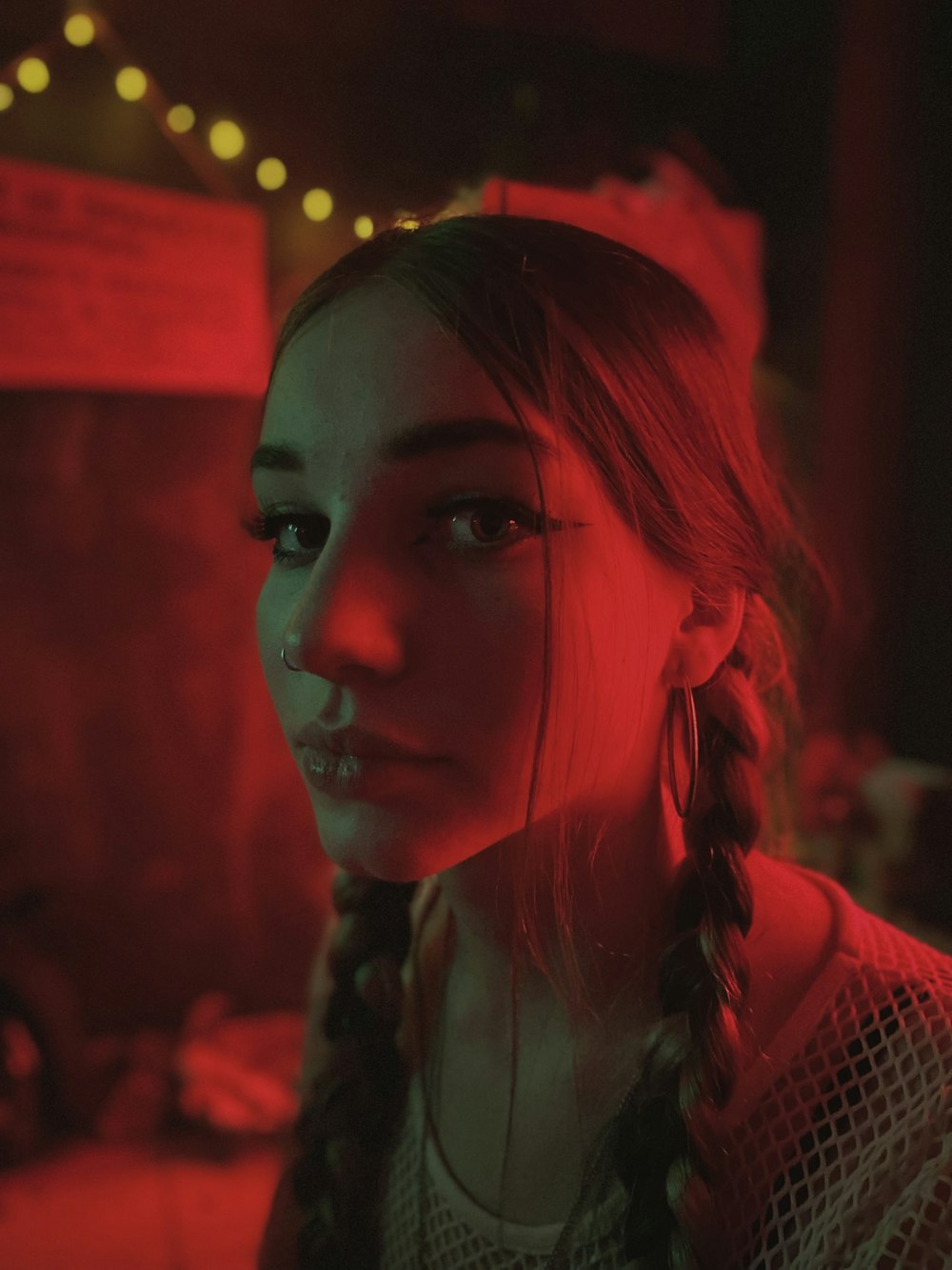 a woman with braids standing in a dark room