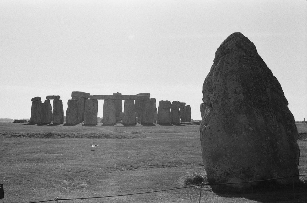 a black and white photo of stonehenge in a field