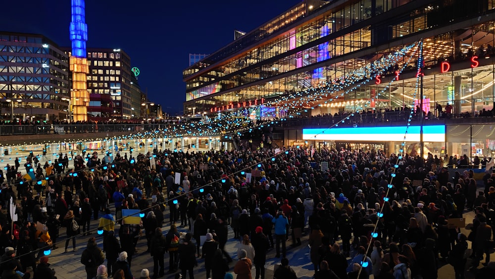 Una folla di persone in piedi intorno a un edificio di notte