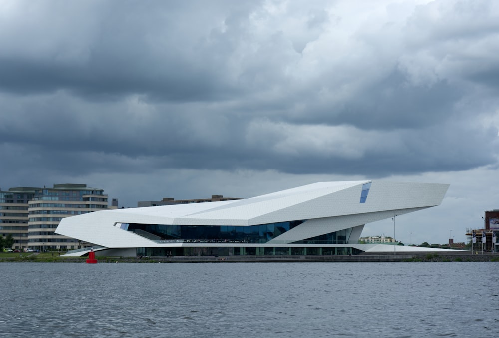 a large white building sitting next to a body of water