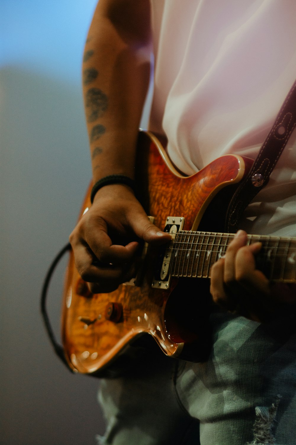 a man playing a guitar while wearing a white shirt