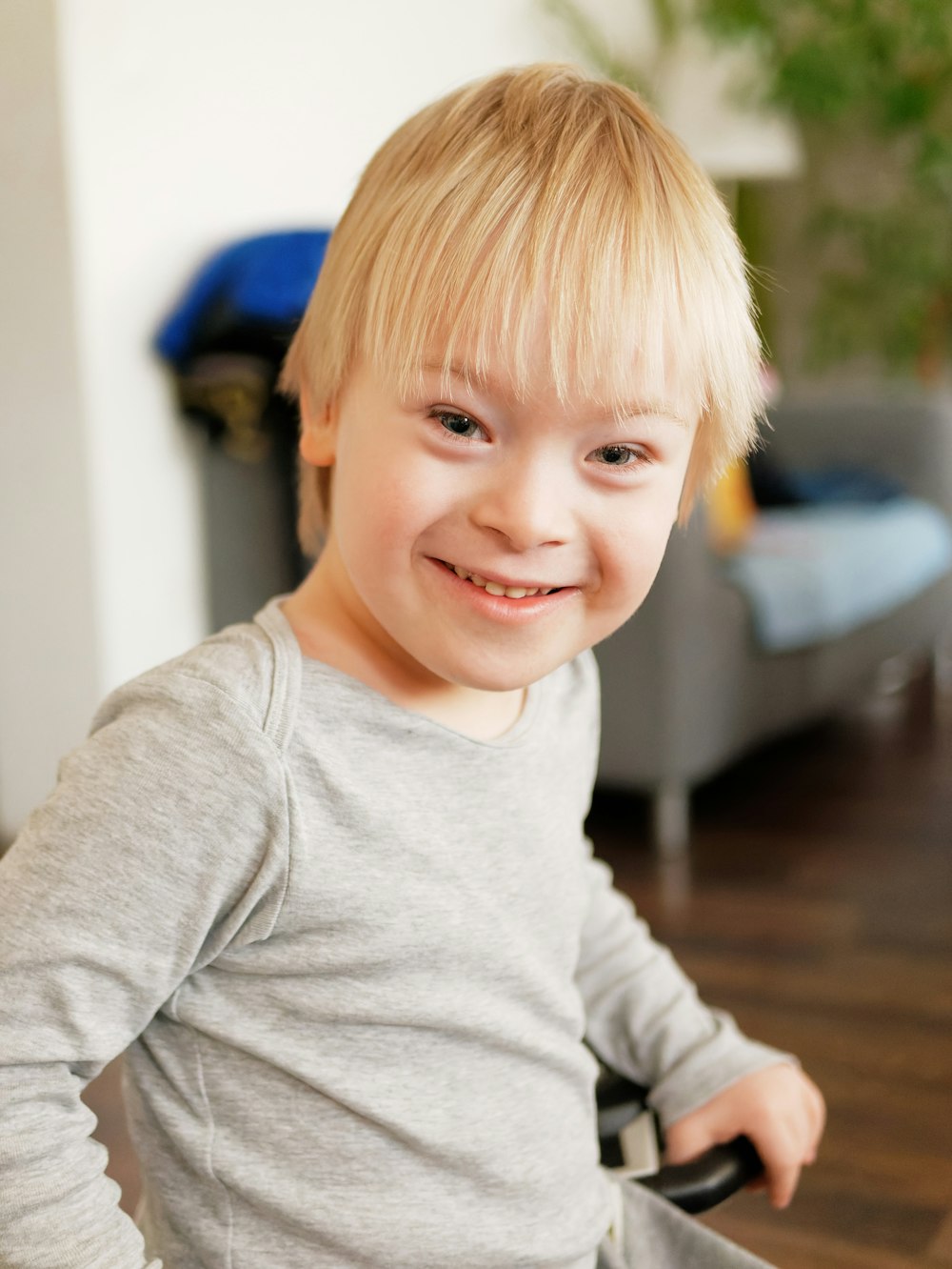 um menino sentado em uma cadeira com um sorriso no rosto