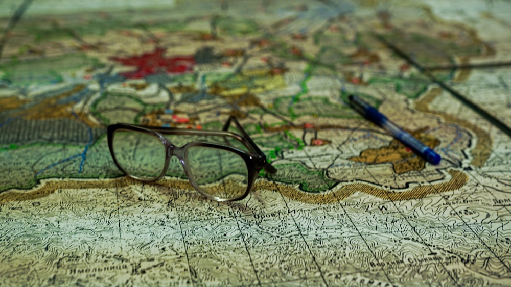 a pair of glasses sitting on top of a map