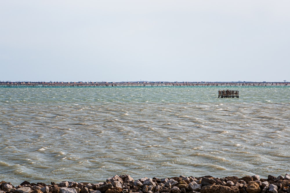 a large body of water with a pier in the distance