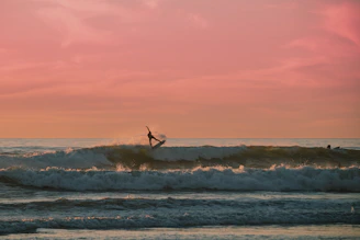 A vibrant photo of a surfer catching a wave at sunset.