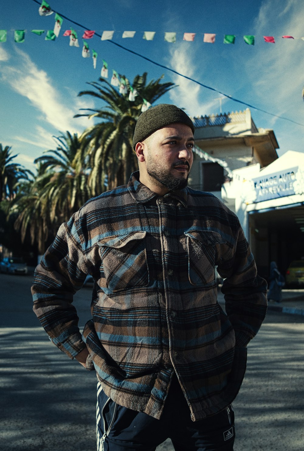 a man standing in the street with his hands on his hips