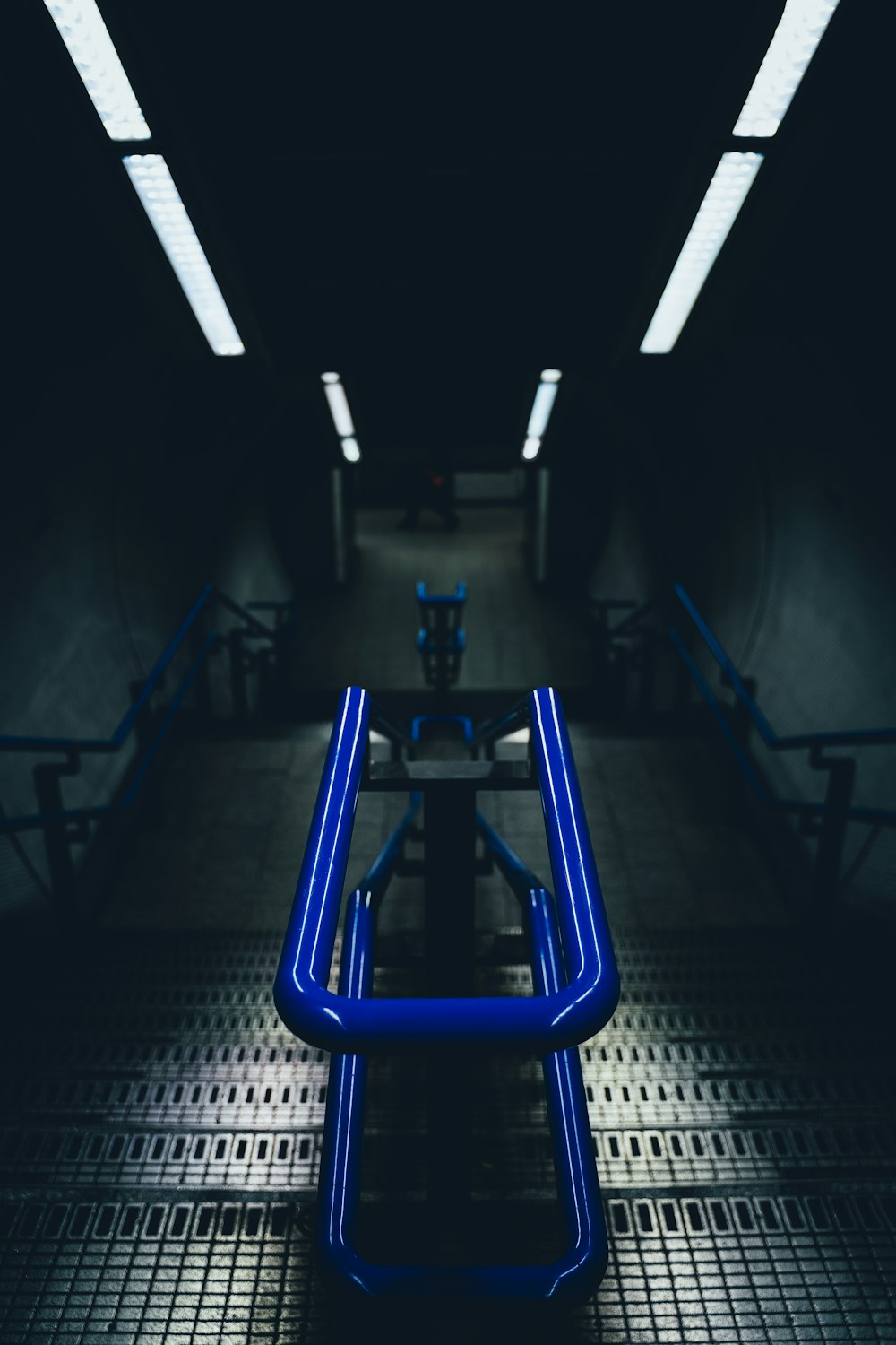 a blue bench sitting in the middle of a hallway