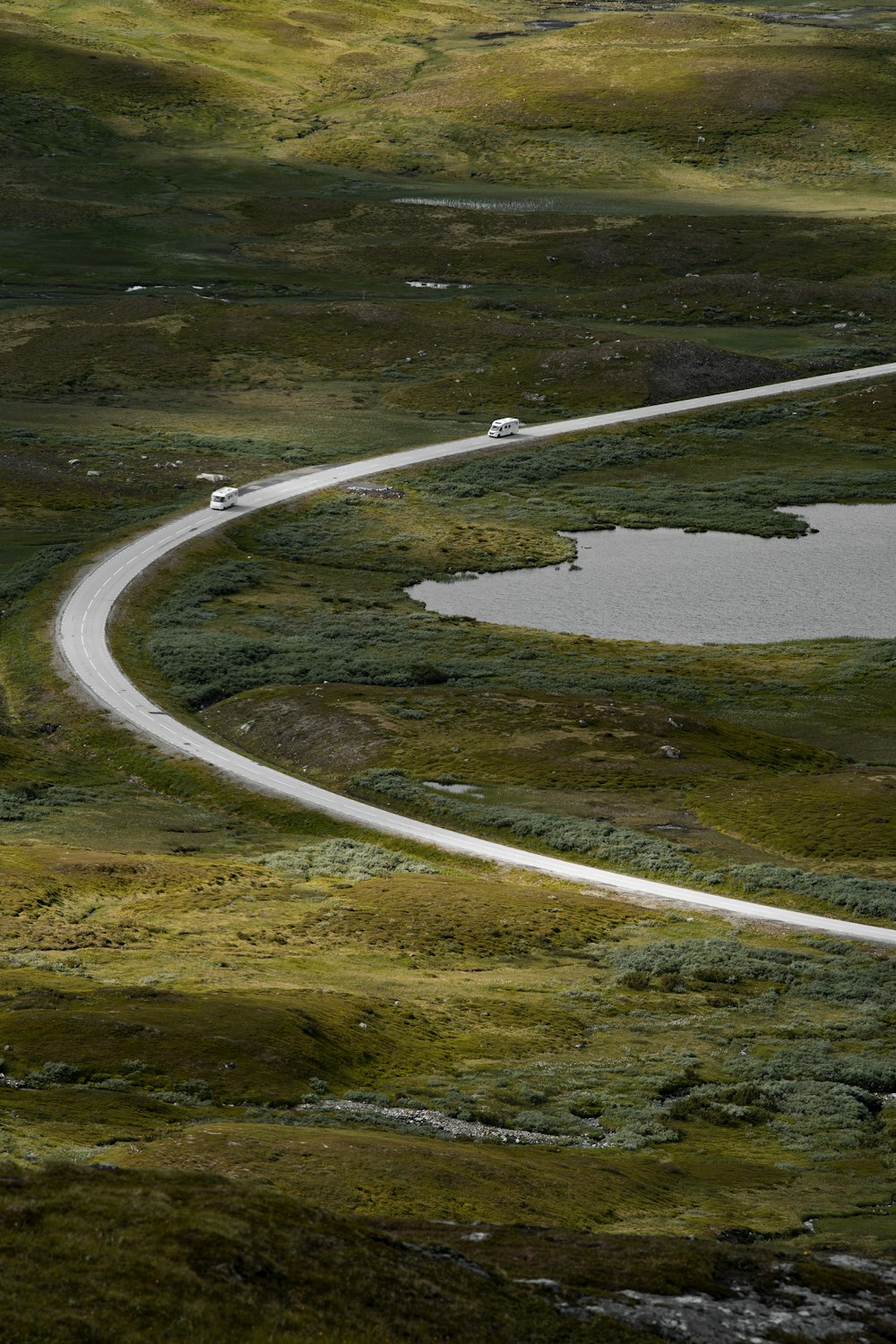 Une route sinueuse au milieu d’un champ herbeux