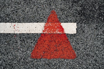 a red and white arrow painted on a road