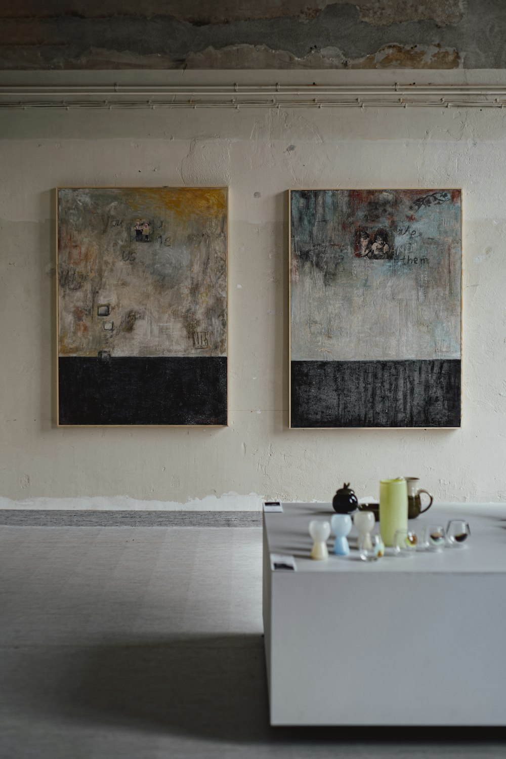 two paintings hang on the wall of a room