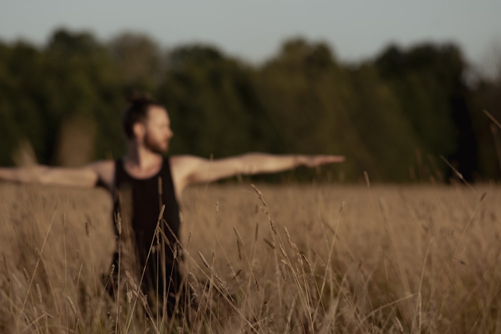 Un uomo in piedi in un campo con le braccia tese