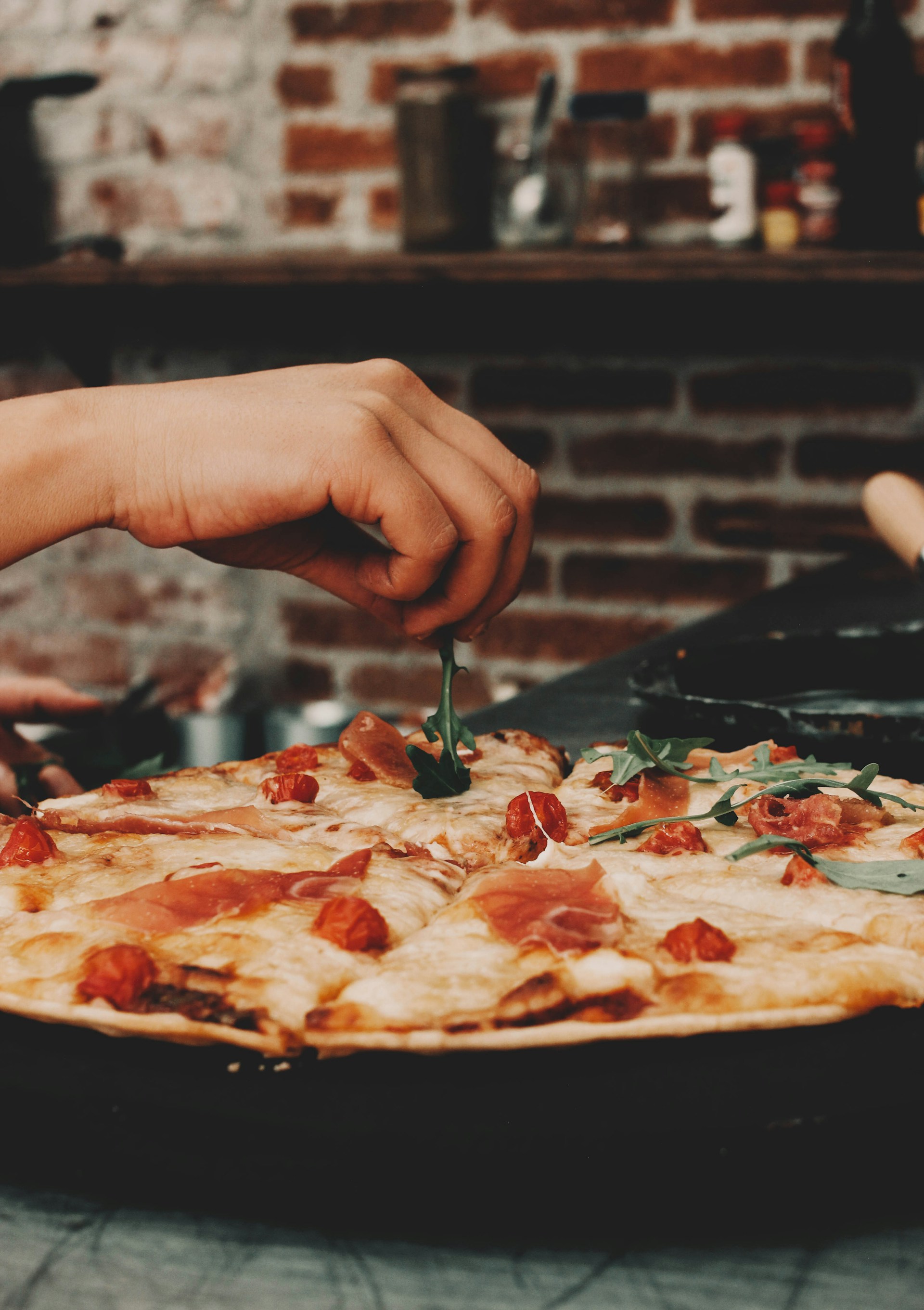 a person cutting a piece of pizza with a knife