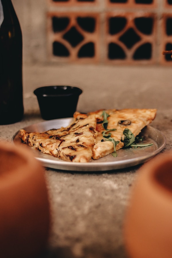 A plate of pizza and a bottle of wine