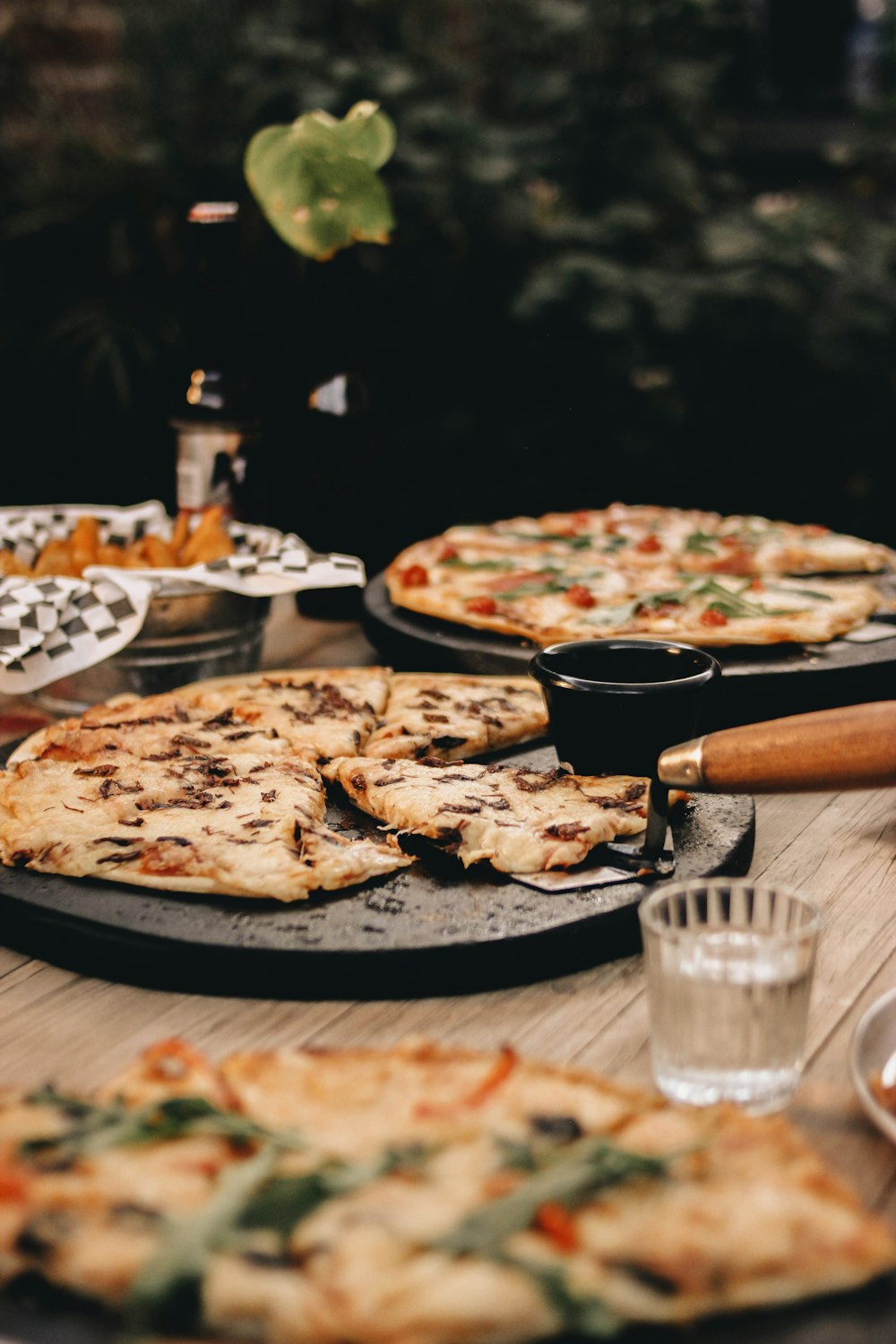 a table topped with pizzas covered in toppings