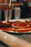 a person pouring sauce on a plate on a counter