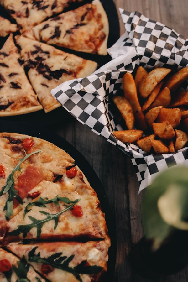 A pizza and some fries on a table