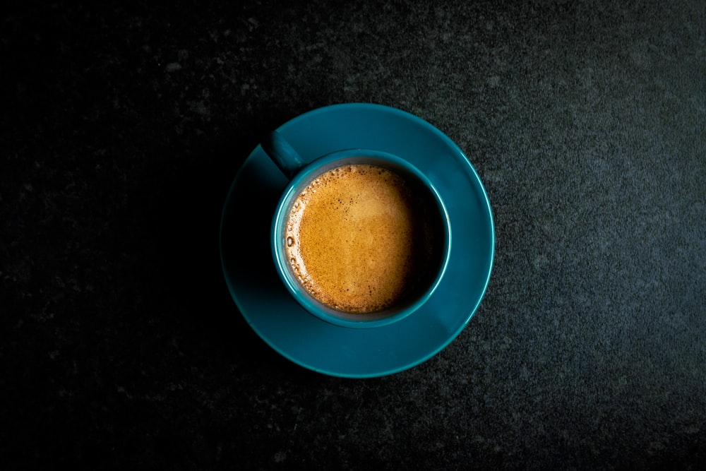 a cup of coffee sitting on top of a blue saucer