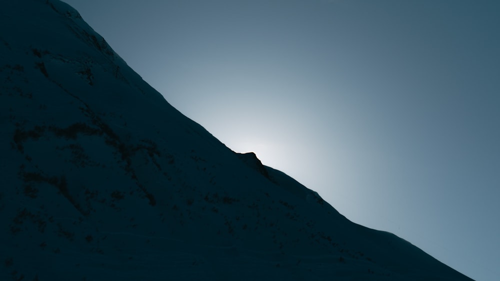 the sun shines brightly on a snowy mountain